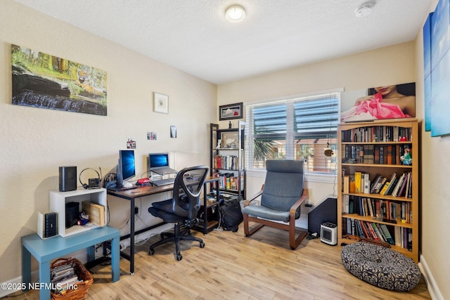 office space featuring a textured ceiling and light wood finished floors