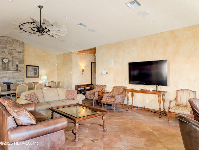 living room with light tile patterned floors, visible vents, vaulted ceiling, and a ceiling fan