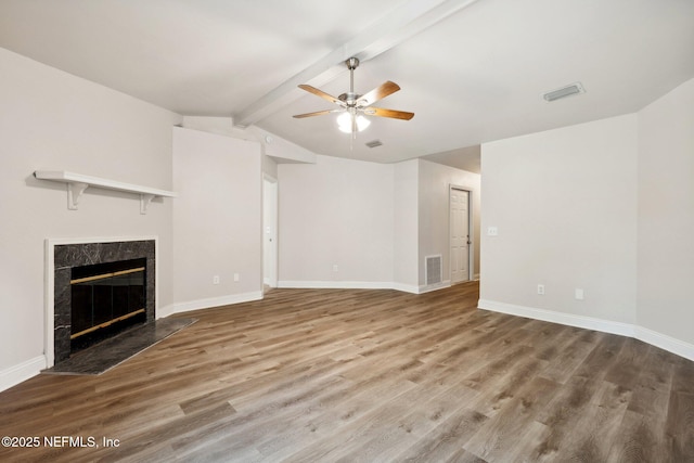 unfurnished living room with lofted ceiling with beams, wood-type flooring, ceiling fan, and a high end fireplace