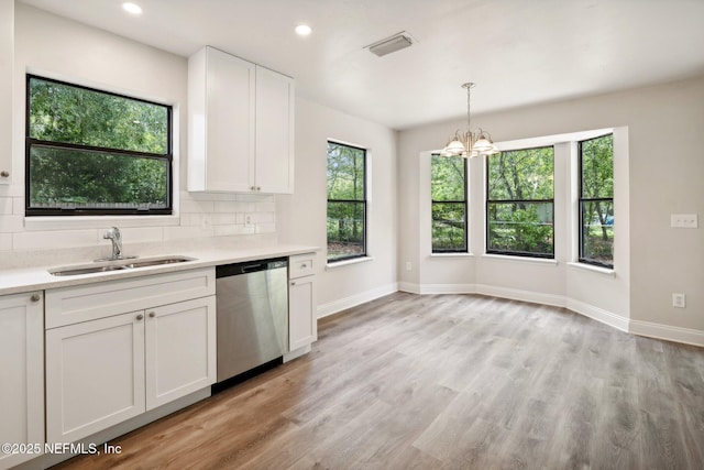 kitchen featuring sink, decorative light fixtures, dishwasher, decorative backsplash, and white cabinets