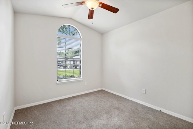 empty room featuring ceiling fan, carpet flooring, and vaulted ceiling