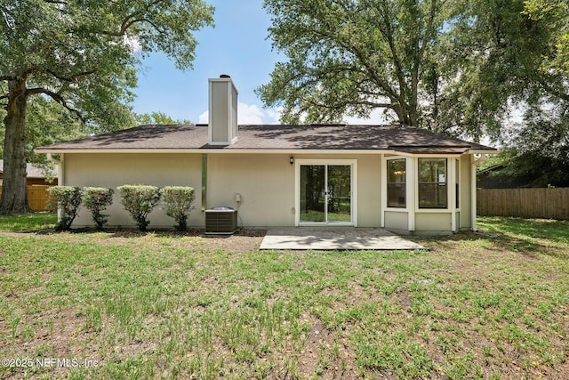 rear view of house featuring central AC unit, a yard, and a patio