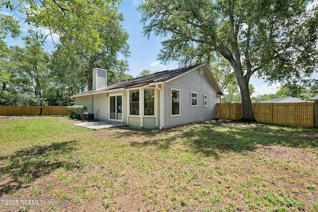 back of property with a lawn, cooling unit, and a patio area