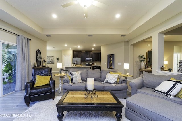 living room featuring light wood-type flooring, visible vents, and recessed lighting