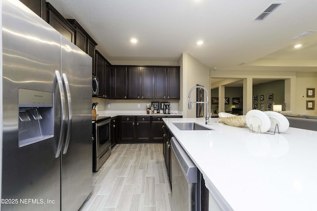 kitchen with recessed lighting, stainless steel appliances, a sink, visible vents, and light countertops