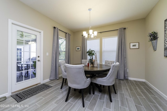 dining area featuring an inviting chandelier, visible vents, baseboards, and wood finish floors