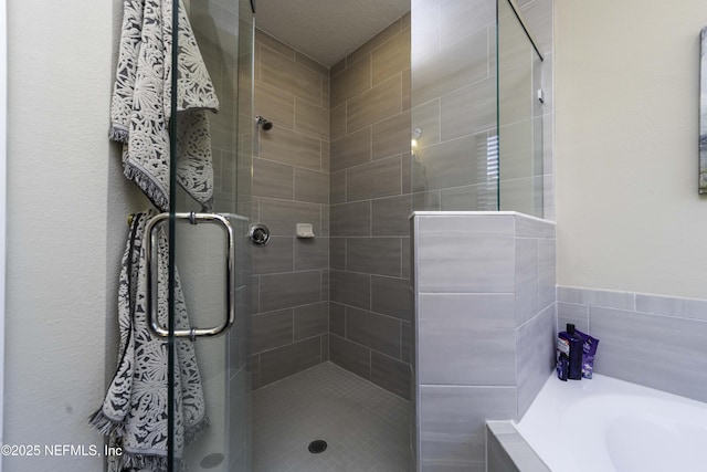 bathroom featuring a shower stall and a bath