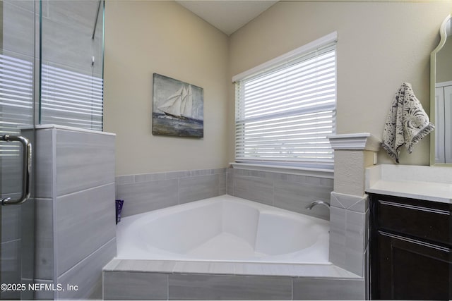 bathroom featuring vanity, a shower with door, and a bath