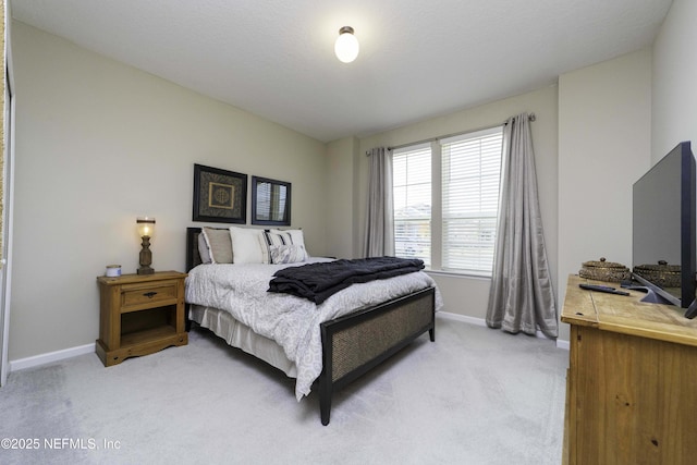 bedroom with light carpet and baseboards