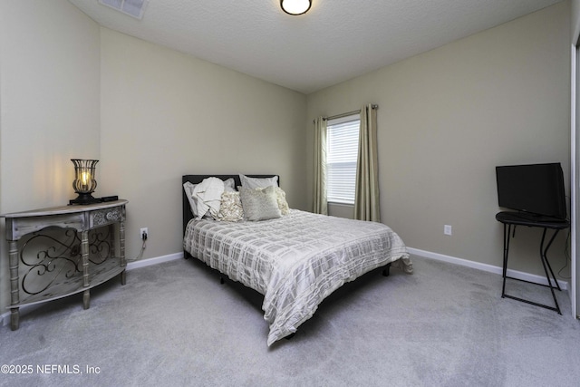 carpeted bedroom featuring a textured ceiling, visible vents, and baseboards