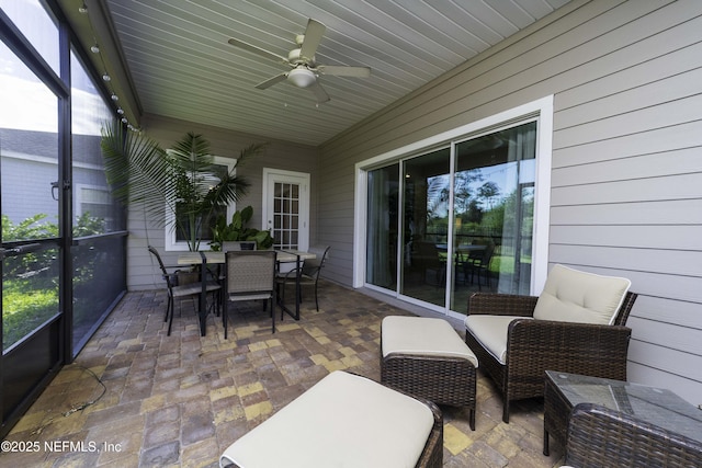 sunroom / solarium with a ceiling fan