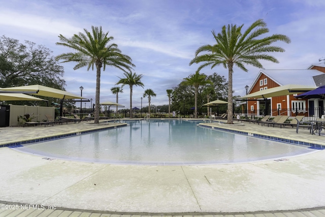 pool with a patio area and fence