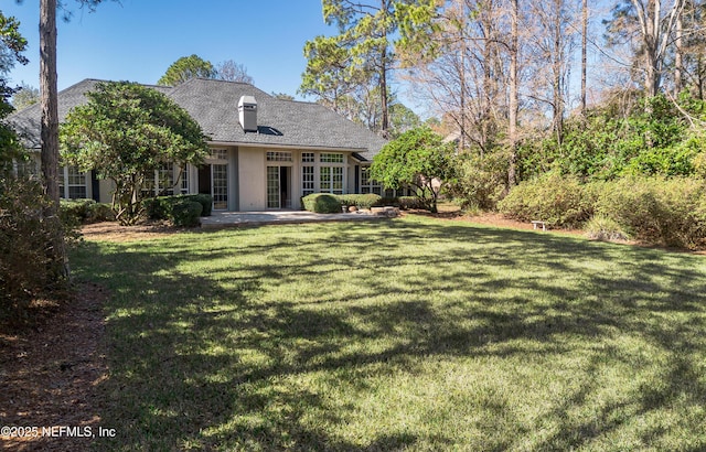 back of property with a yard and a patio area