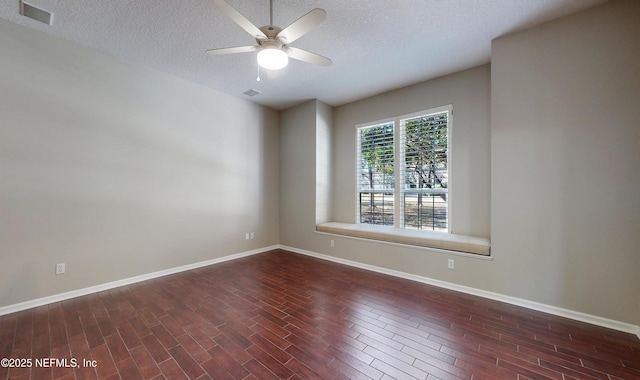 empty room with a textured ceiling, dark wood-type flooring, and ceiling fan