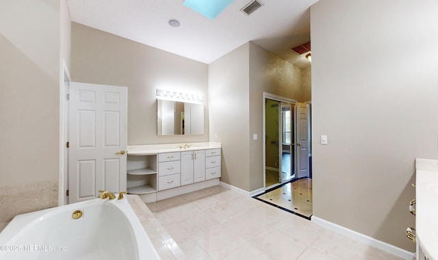 bathroom featuring vanity, a bathtub, and a skylight