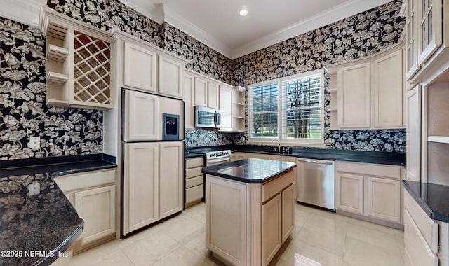 kitchen featuring a kitchen island, appliances with stainless steel finishes, sink, ornamental molding, and cream cabinets