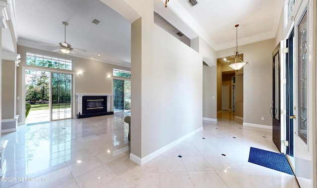 hall featuring a high ceiling, ornamental molding, and light tile patterned flooring