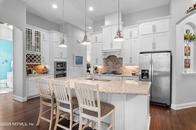 kitchen with appliances with stainless steel finishes, pendant lighting, and white cabinets