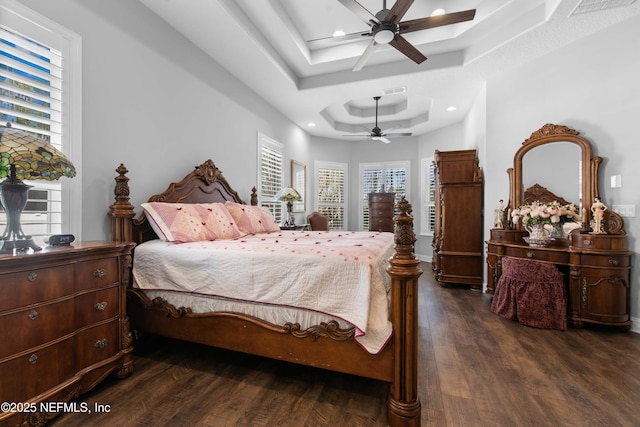 bedroom featuring multiple windows, ceiling fan, dark hardwood / wood-style flooring, and a tray ceiling