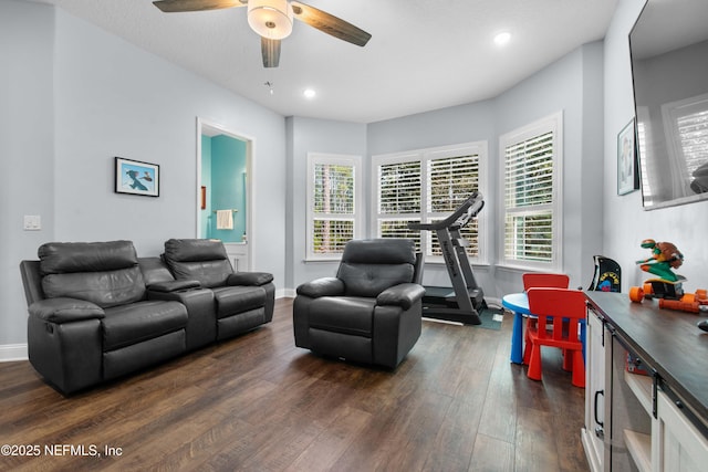 living room with dark wood-type flooring and ceiling fan