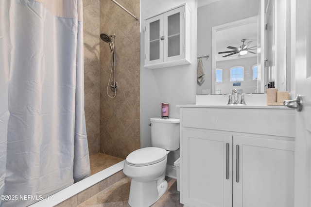 bathroom featuring vanity, ceiling fan, toilet, and walk in shower