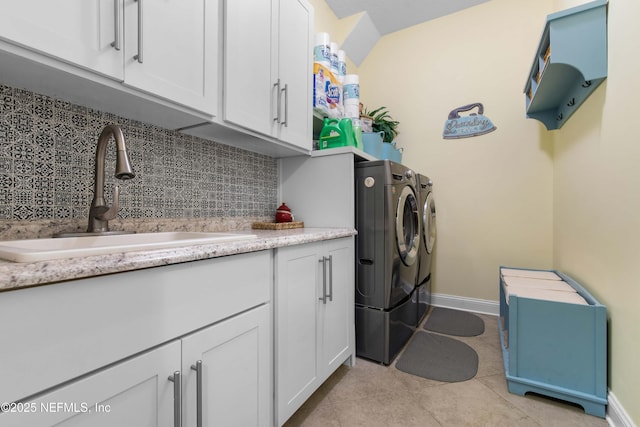 laundry area featuring sink, light tile patterned floors, cabinets, and independent washer and dryer