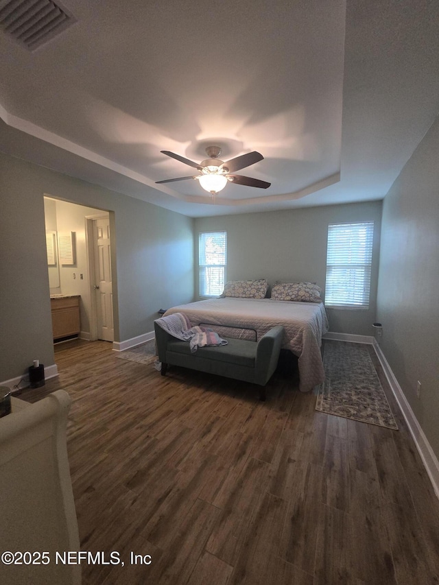 bedroom with ensuite bathroom, ceiling fan, and dark hardwood / wood-style flooring