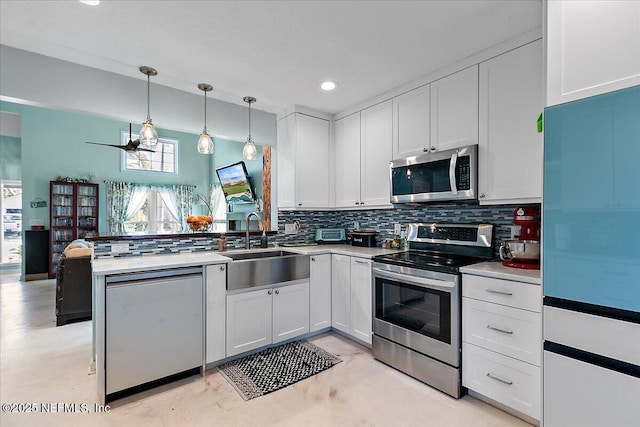 kitchen with white cabinetry, hanging light fixtures, sink, and appliances with stainless steel finishes