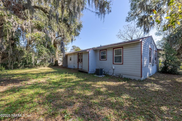 back of property with a yard and central air condition unit