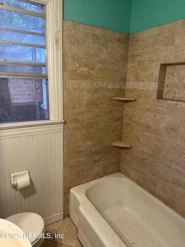 bathroom with a bath, tile patterned floors, and toilet