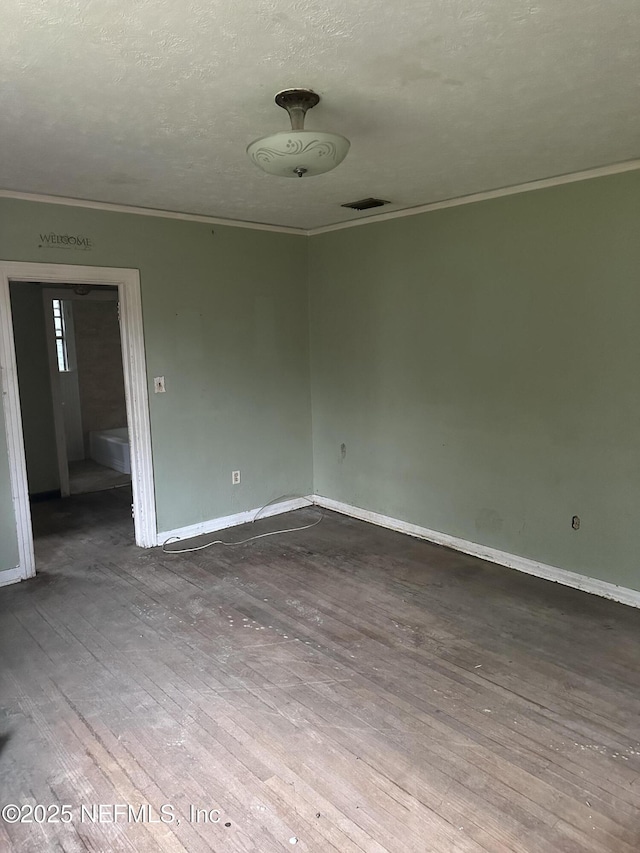 spare room with hardwood / wood-style flooring, ornamental molding, and a textured ceiling