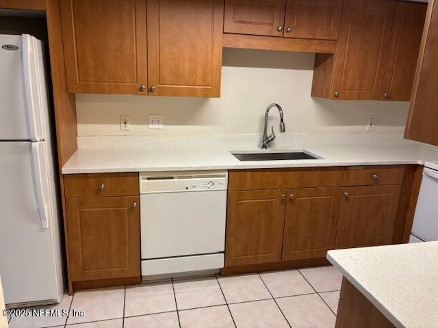 kitchen with sink, white appliances, and light tile patterned floors