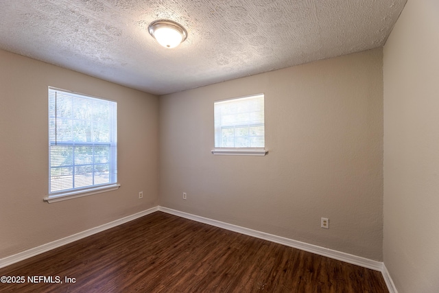 unfurnished room with dark hardwood / wood-style floors and a textured ceiling