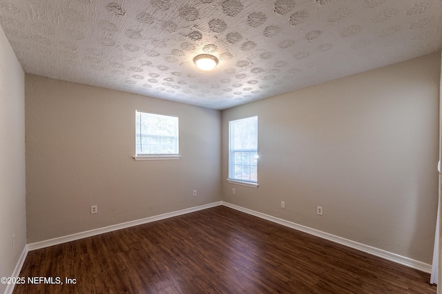 unfurnished room with dark hardwood / wood-style flooring