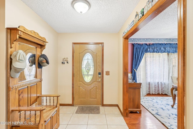 foyer with a textured ceiling and light tile patterned flooring