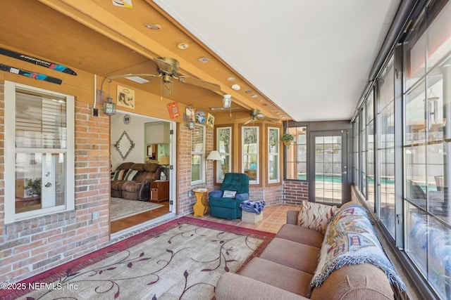 sunroom with beam ceiling and ceiling fan