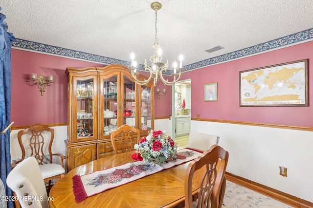 dining room featuring an inviting chandelier and a textured ceiling