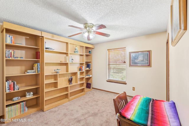 living area featuring ceiling fan, light carpet, and a textured ceiling