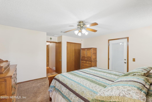 carpeted bedroom featuring ceiling fan, a closet, and a textured ceiling