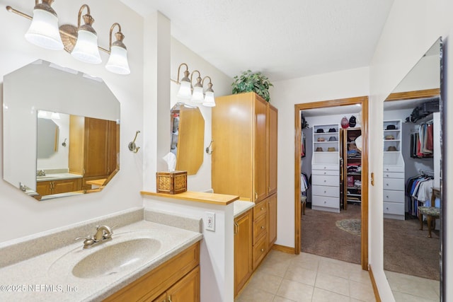 bathroom with tile patterned flooring, vanity, and a textured ceiling