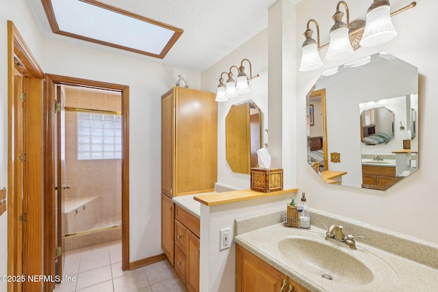 bathroom with vanity, tile patterned flooring, and a tile shower