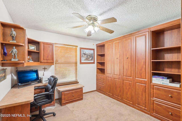 carpeted office space featuring ceiling fan and a textured ceiling