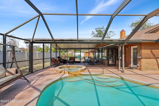 view of pool with an in ground hot tub, glass enclosure, and a patio