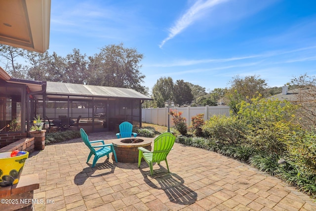 view of patio featuring a fire pit and a sunroom