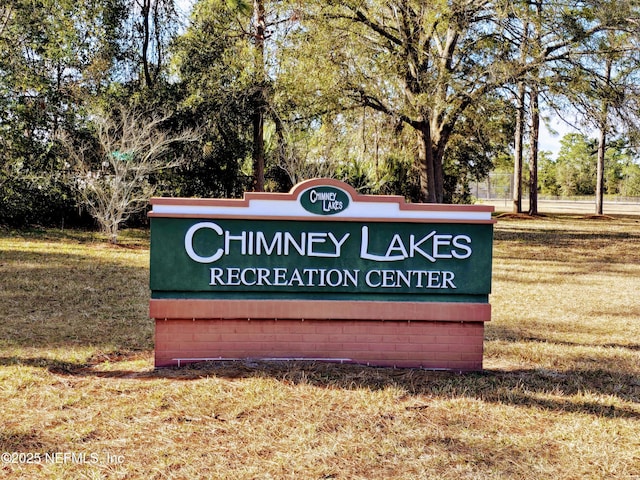 community / neighborhood sign featuring a yard