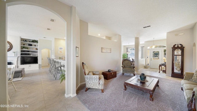 tiled living room featuring built in features and a textured ceiling