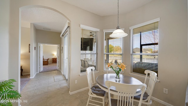 dining space with light tile patterned flooring and a textured ceiling