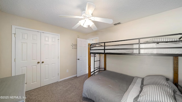 bedroom featuring ceiling fan, a closet, a textured ceiling, and carpet flooring