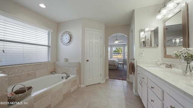 bathroom with vanity, tile patterned flooring, a relaxing tiled tub, and a textured ceiling