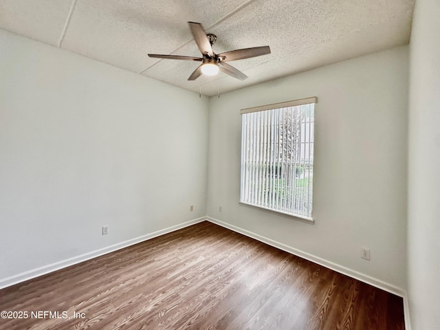 empty room featuring ceiling fan, hardwood / wood-style floors, and a textured ceiling